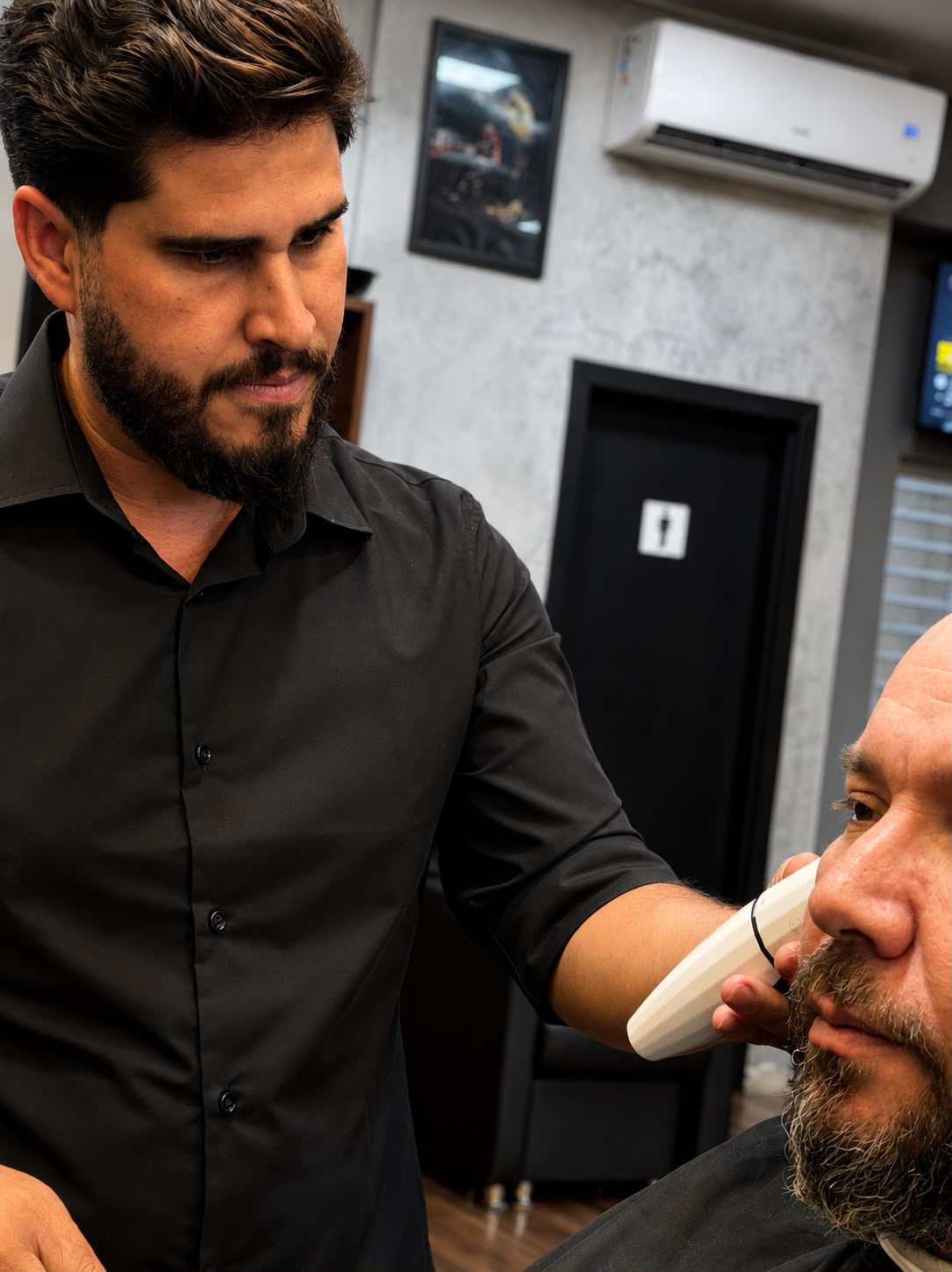 Barbeiro aparando a barba de um cliente na Dom Quixote